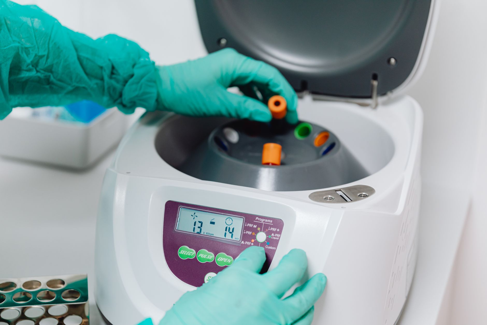 Gros plan d'un technicien de laboratoire utilisant une centrifugeuse pour traiter des échantillons de sang dans un laboratoire médical.